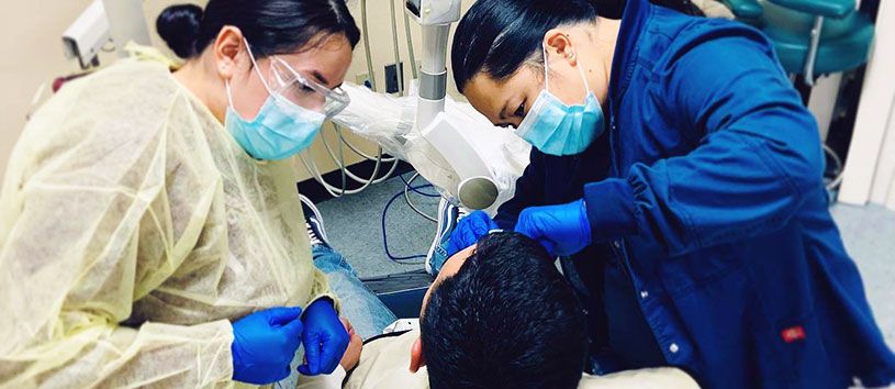 Dental Assistant students practicing on a patient.