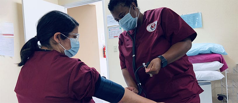 Student practicing phlebotomy technique on another student.