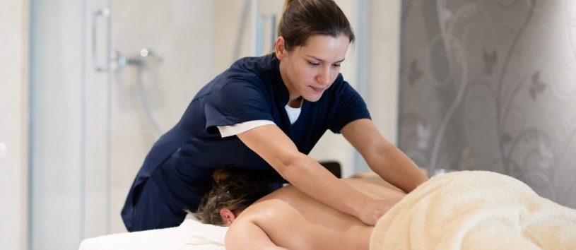Masseur treating patient with therapeutic massage treatment