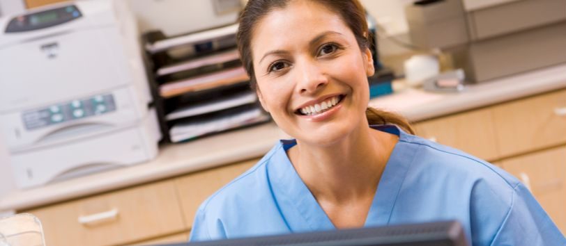 Medical Biller and Coder sitting at a computer.